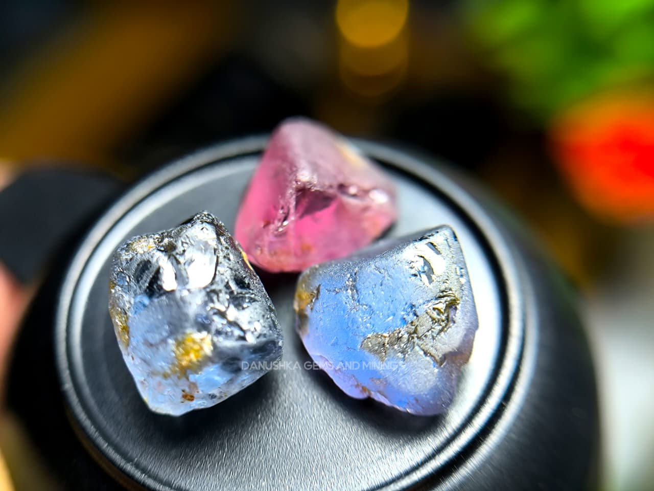 Three-piece facet-grade Spinel rough parcel with color-change, purplish pink, and blue Spinel stones showing natural inclusions and cutting potential.